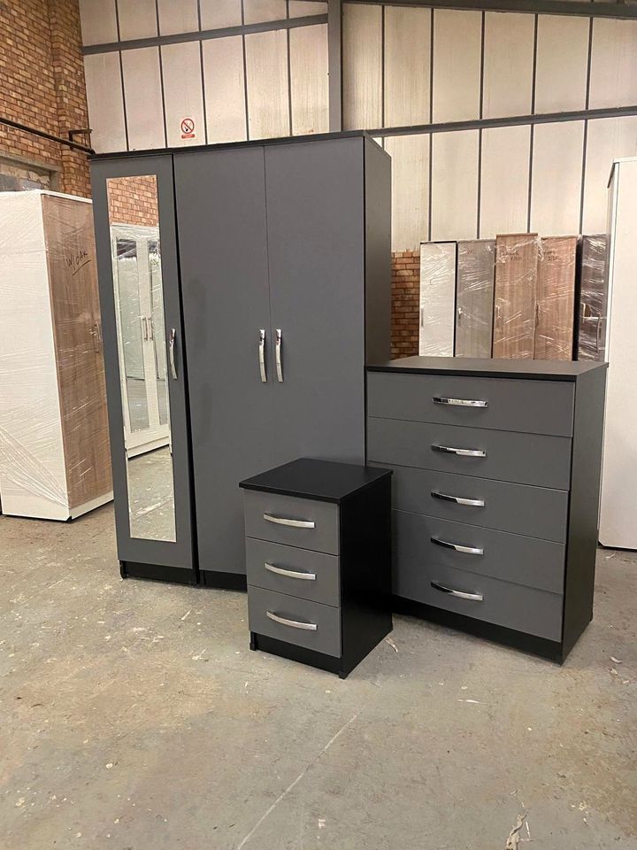 a mirrored wardrobe, chest of drawers, and a bedside table