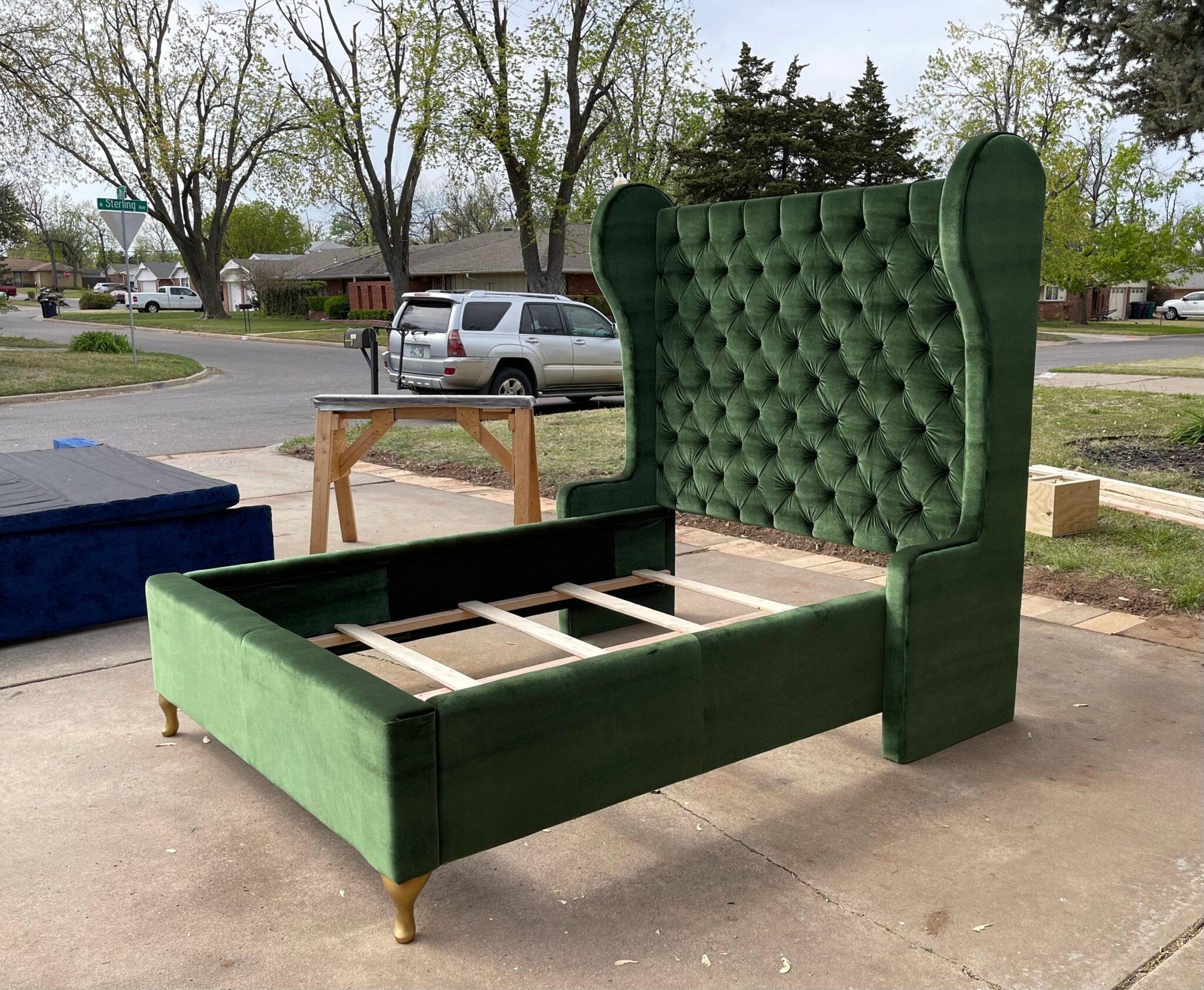 a custom green velvet wingback tufted bed